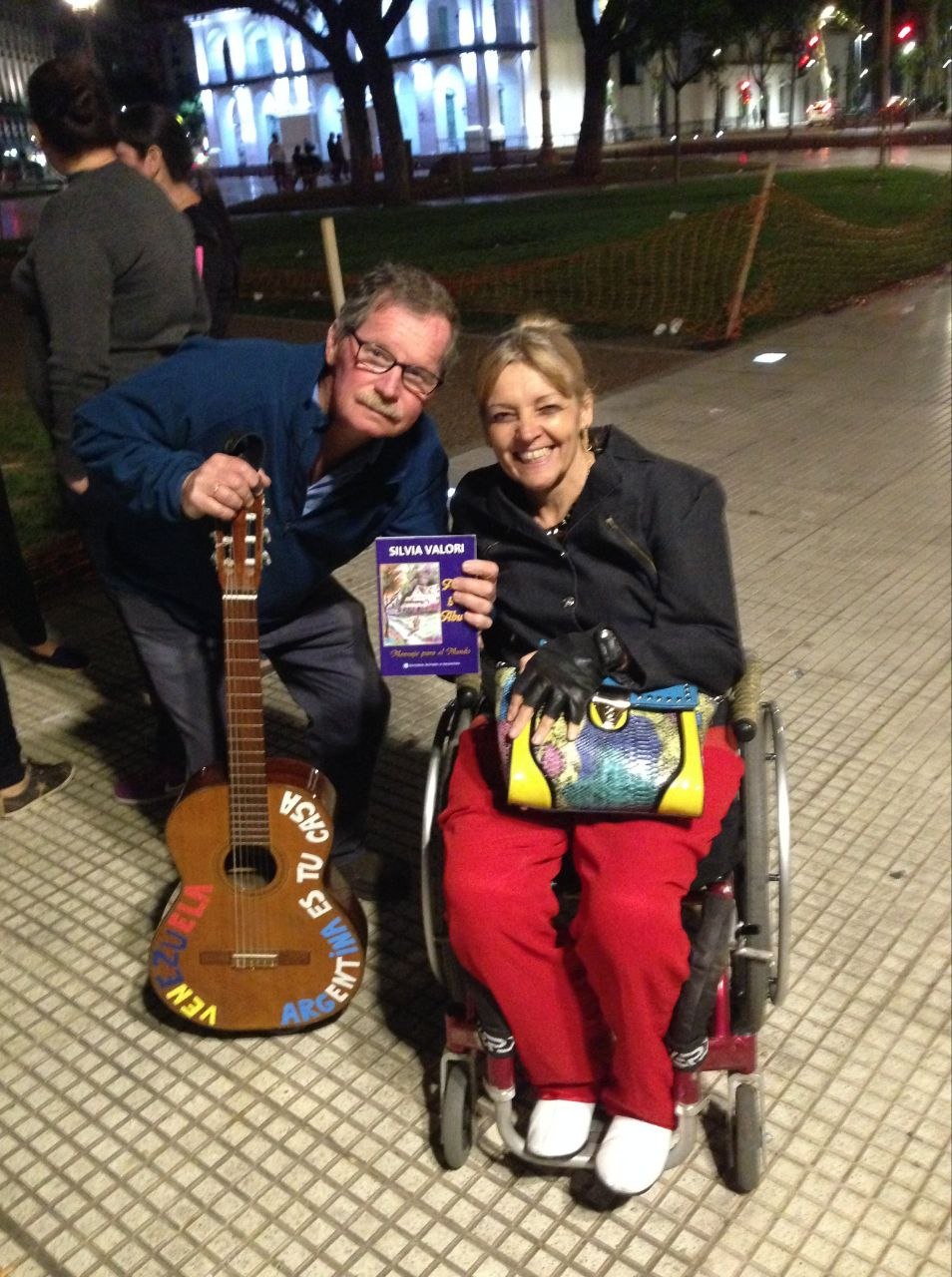 Silvia Mirta Valori junto a Juan Carr, de la Red Solidaria, que sostiene el libro Adam y el Abuelo en Plaza de Mayo